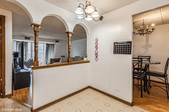 dining area with an inviting chandelier, baseboards, and a textured ceiling