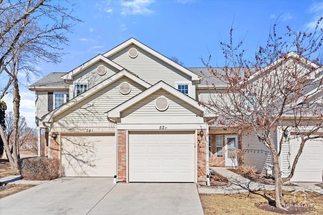 traditional home featuring an attached garage, driveway, and brick siding