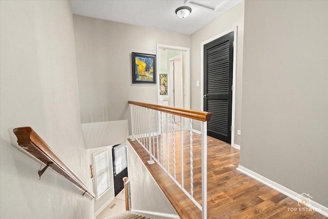 staircase with wood finished floors and baseboards