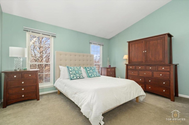 bedroom with lofted ceiling, light carpet, and baseboards