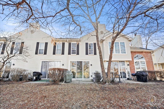 exterior space featuring a chimney and a patio