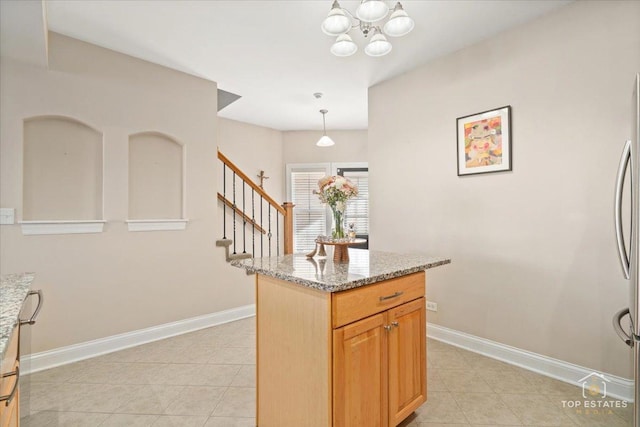 kitchen featuring light tile patterned floors, hanging light fixtures, baseboards, and light stone countertops