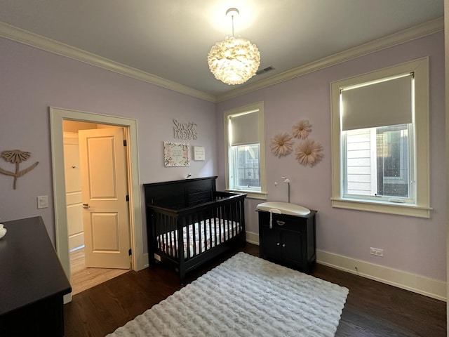 bedroom with ornamental molding, dark wood-style flooring, visible vents, and baseboards