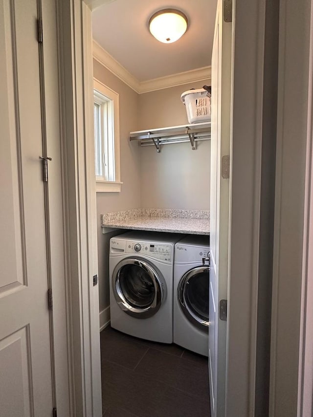 laundry room featuring washing machine and dryer, laundry area, dark tile patterned flooring, and crown molding