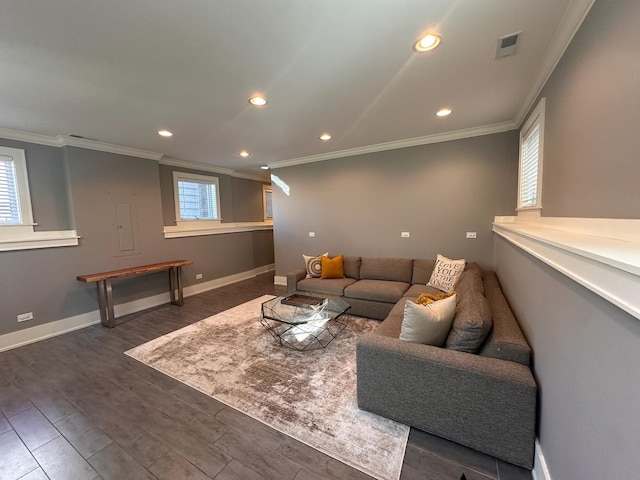 living room featuring a wealth of natural light, visible vents, crown molding, and wood finished floors