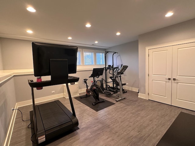 workout room with recessed lighting, baseboards, and wood finished floors