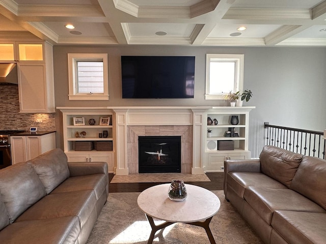 living room with a tiled fireplace, ornamental molding, coffered ceiling, and beam ceiling