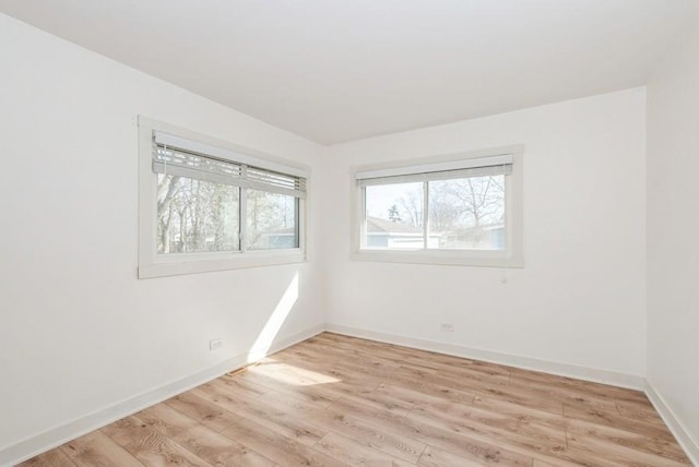 empty room with baseboards and light wood-type flooring