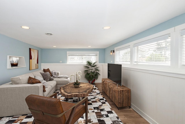 living area with a wainscoted wall, recessed lighting, and light wood-type flooring