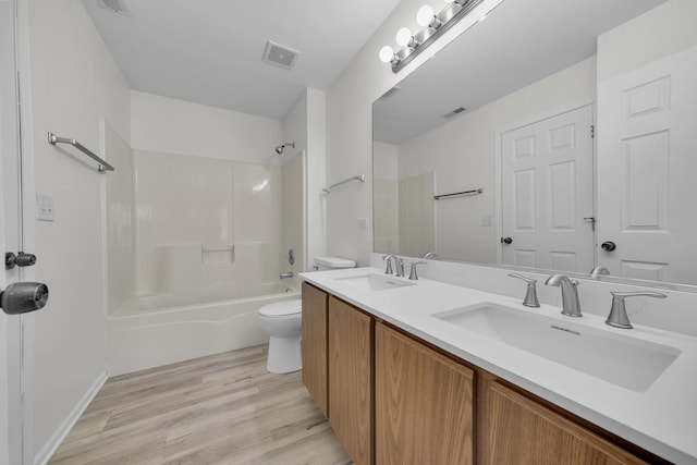 bathroom with visible vents, a sink, toilet, and wood finished floors