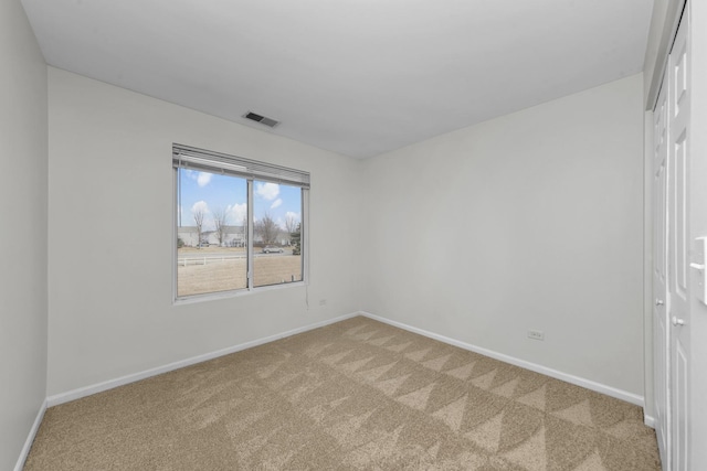 unfurnished room featuring baseboards, visible vents, and light colored carpet