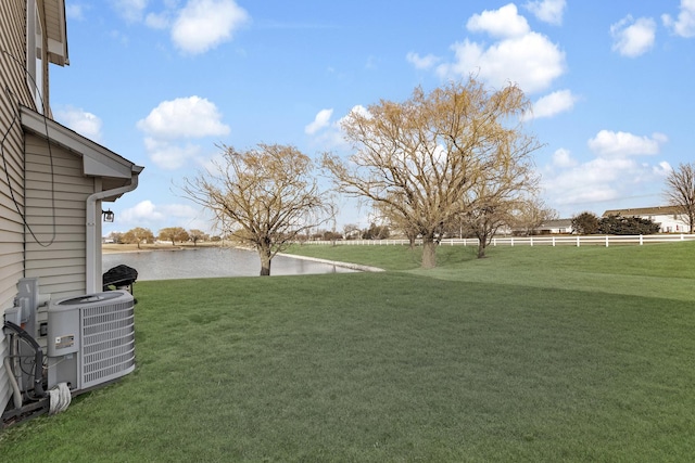 view of yard featuring a water view and central AC unit