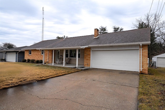 ranch-style house featuring a porch, brick siding, driveway, and a chimney