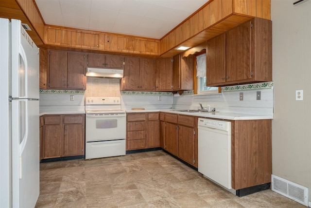 kitchen featuring white appliances, visible vents, light countertops, under cabinet range hood, and a sink