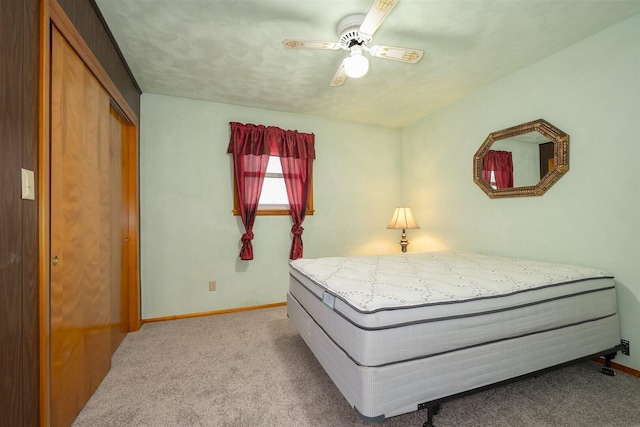 carpeted bedroom with a closet, ceiling fan, and baseboards