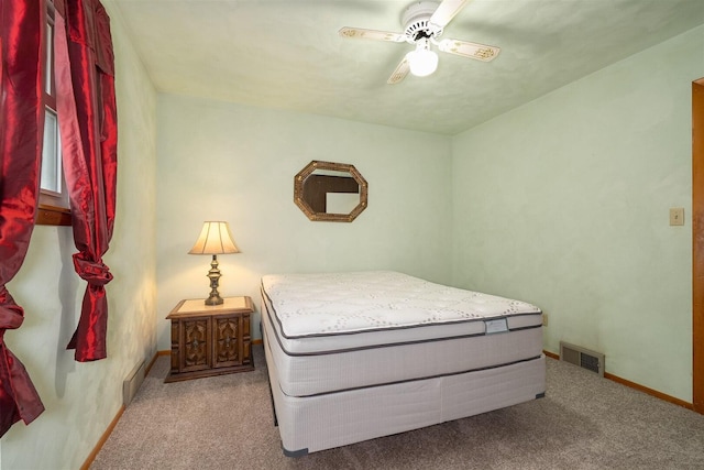 carpeted bedroom featuring a ceiling fan, visible vents, and baseboards