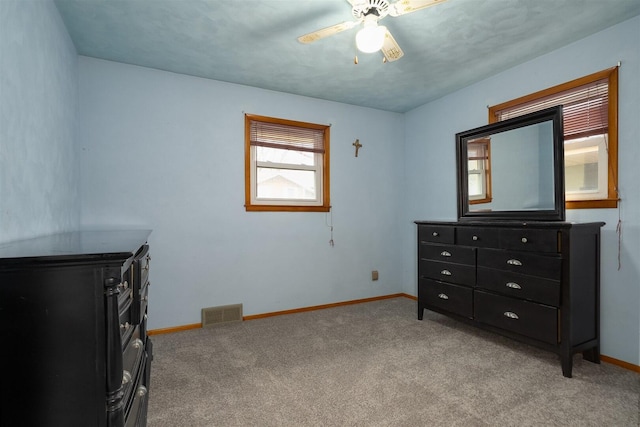 bedroom featuring light carpet, ceiling fan, visible vents, and baseboards