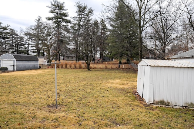 view of yard with fence, a storage unit, and an outdoor structure