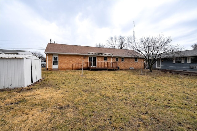 rear view of house featuring an outbuilding, a storage shed, brick siding, a lawn, and a wooden deck