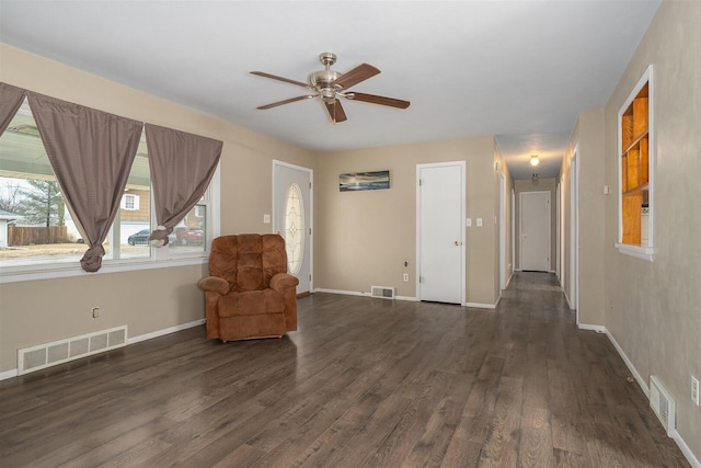 unfurnished room featuring dark wood-type flooring, visible vents, and baseboards