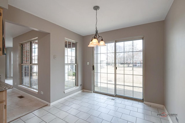 unfurnished dining area with visible vents, baseboards, and an inviting chandelier