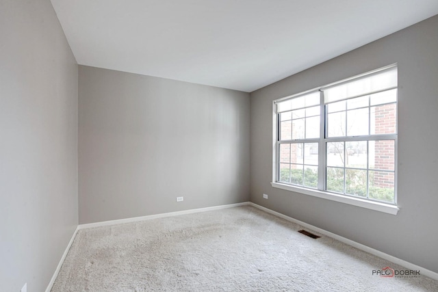 unfurnished room featuring baseboards, visible vents, and carpet flooring