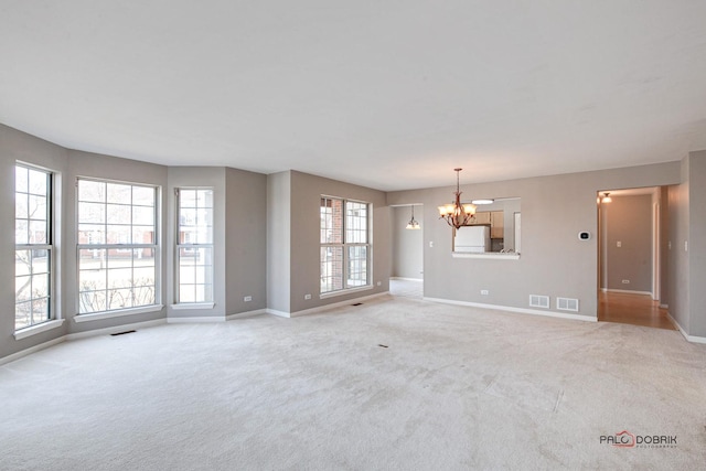 unfurnished living room with light carpet, baseboards, visible vents, and a notable chandelier