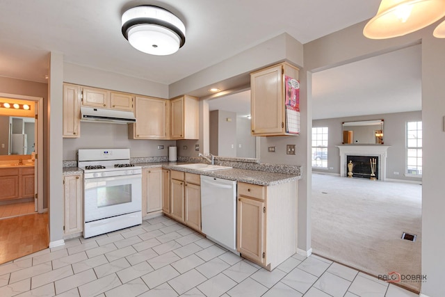 kitchen featuring white appliances, under cabinet range hood, light countertops, and a sink