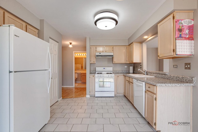 kitchen with white appliances, range hood, light brown cabinets, and a sink