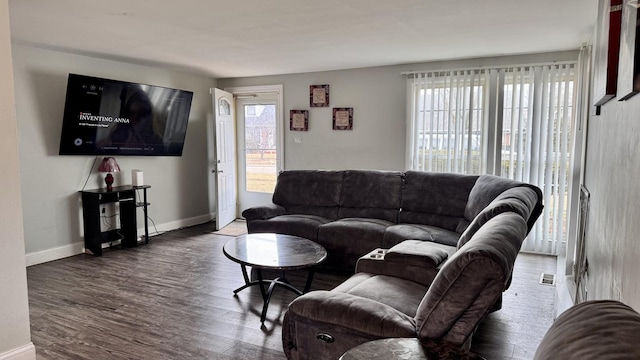 living area with visible vents, baseboards, and wood finished floors