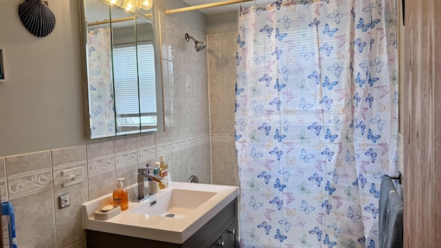 full bathroom featuring a shower with curtain, tile walls, and vanity