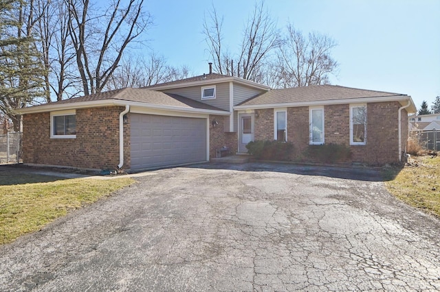 single story home with brick siding, driveway, and an attached garage