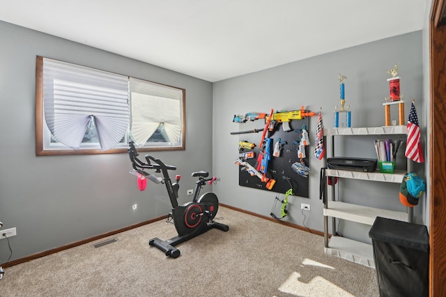 workout area featuring baseboards and carpet