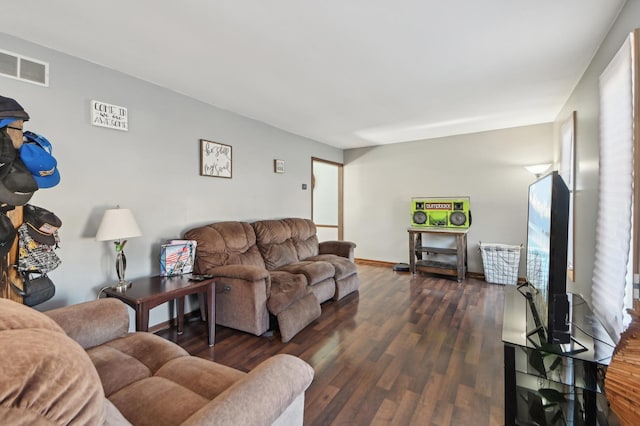 living room featuring visible vents, baseboards, and dark wood-type flooring