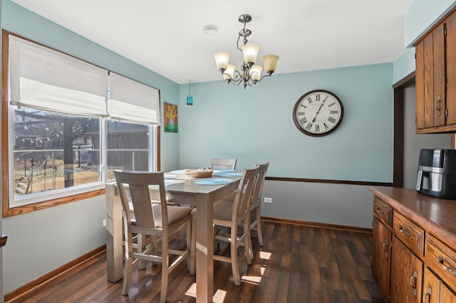 dining area with a notable chandelier, baseboards, and dark wood-style flooring