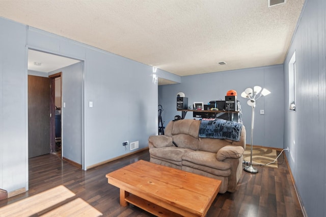 living area with baseboards, wood finished floors, visible vents, and a textured ceiling