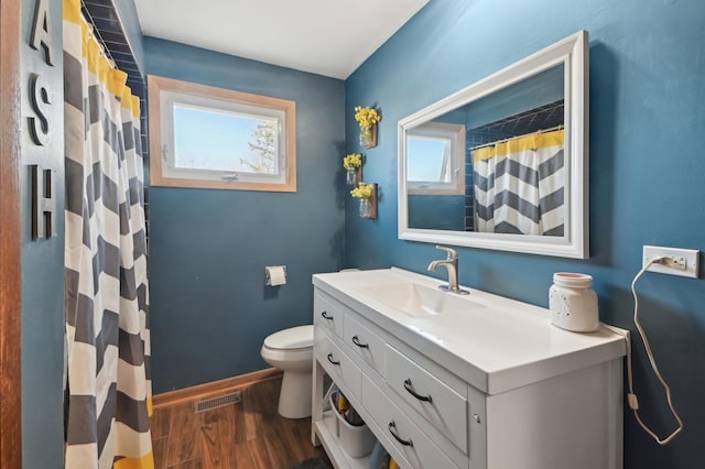 full bathroom with visible vents, baseboards, toilet, wood finished floors, and vanity