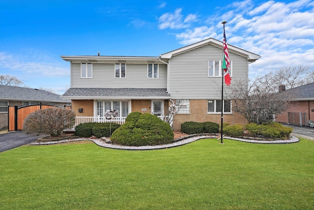 traditional-style home with brick siding, a porch, and a front yard