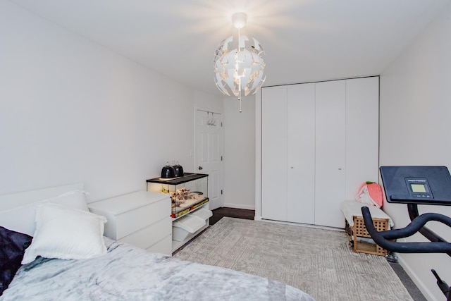 bedroom with a closet, a notable chandelier, and baseboards