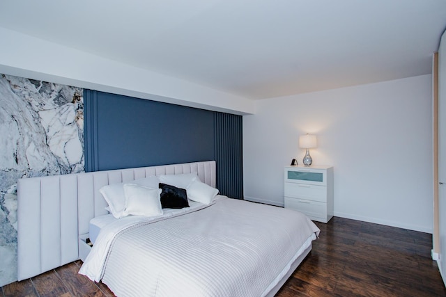 bedroom featuring baseboards and wood finished floors