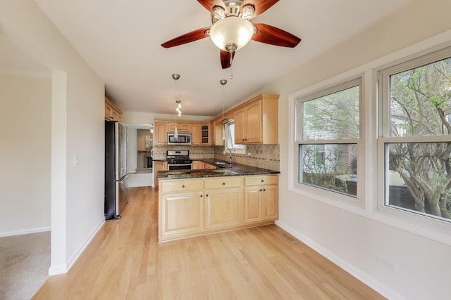 kitchen with plenty of natural light, appliances with stainless steel finishes, tasteful backsplash, and baseboards