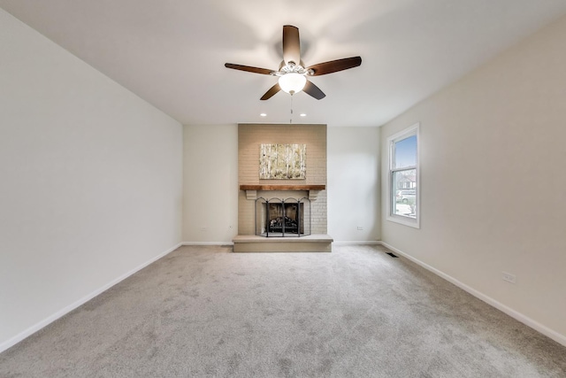 unfurnished living room featuring ceiling fan, a brick fireplace, carpet, recessed lighting, and baseboards