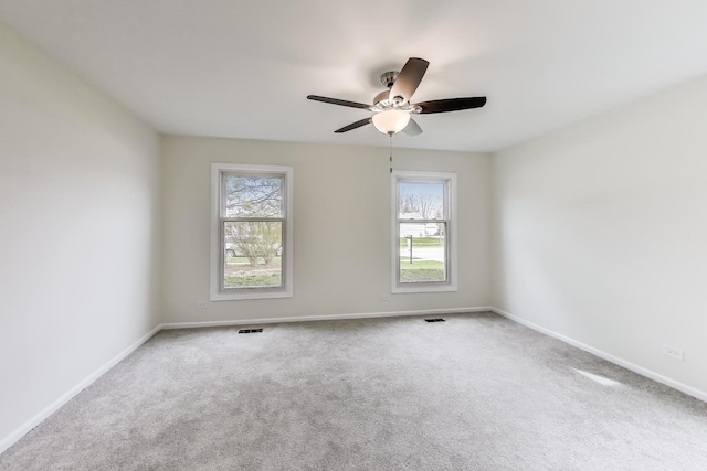 spare room featuring visible vents, carpet flooring, baseboards, and ceiling fan