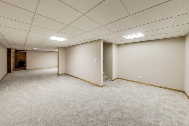 finished basement with baseboards, carpet flooring, and a paneled ceiling
