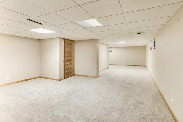 finished below grade area featuring baseboards, carpet flooring, and a paneled ceiling