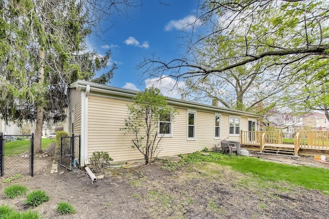 back of property with fence, a wooden deck, and a chimney