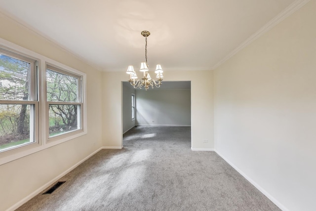 carpeted empty room featuring crown molding, baseboards, a notable chandelier, and visible vents