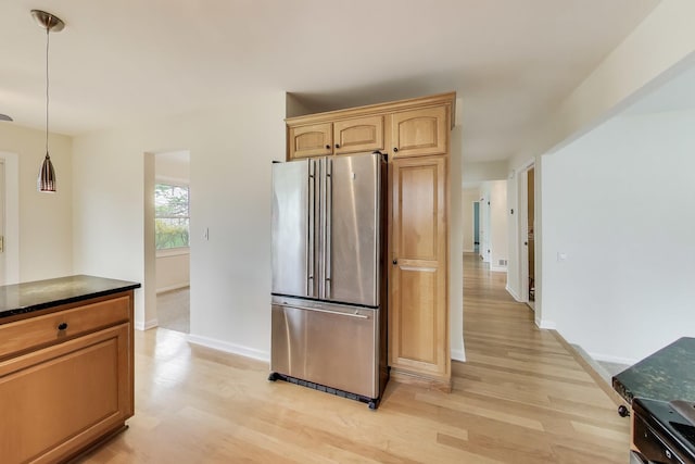 kitchen with baseboards, freestanding refrigerator, light wood-type flooring, and decorative light fixtures