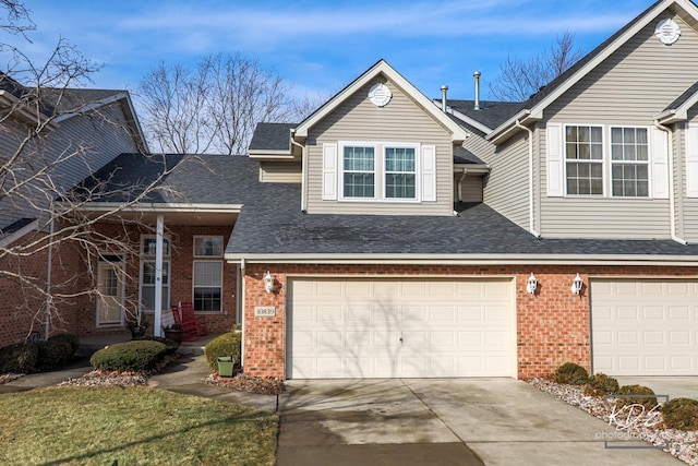 view of front of home featuring a garage, brick siding, roof with shingles, and driveway