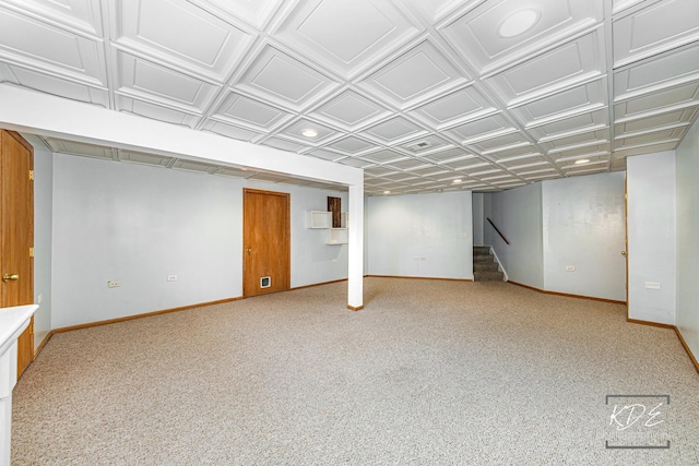 finished below grade area with an ornate ceiling, carpet floors, stairway, and baseboards